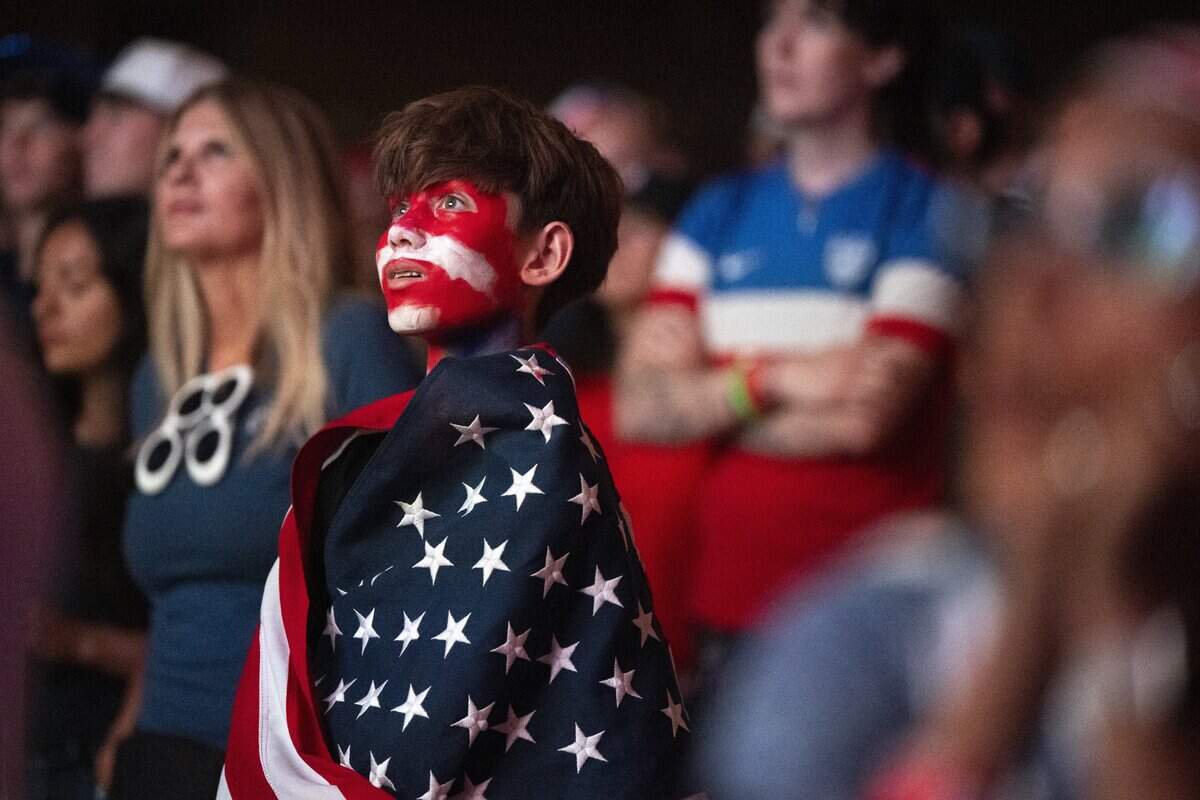 Miles Branch wears an American flag during a watch party at Memorial Auditorium in Sacramento on Wednesday as he watches the U.S. men's soccer team face off against Bosnia and Herzegovina in the World Cup. The game, which the U.S. won 2-0, was played in Santa Clara.