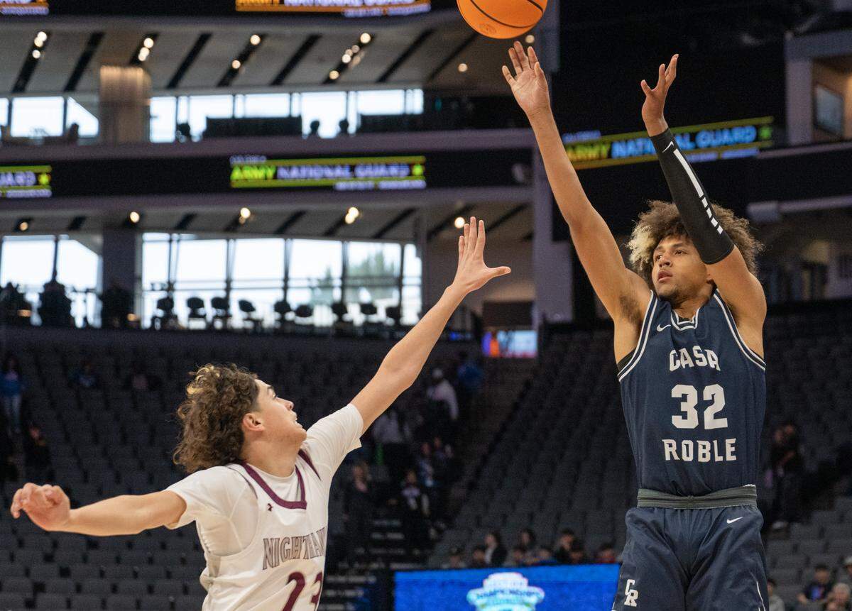 Casa Roble forward Mason Pearcy (32) takes a 3-point shot as Natomas Nighthawks guard Diego Villanueva (23) defends in the first half of the CIF Sac-Joaquin Section Division IV boys basketball section championship at Golden 1 Center on Thursday, Feb. 27, 2025.