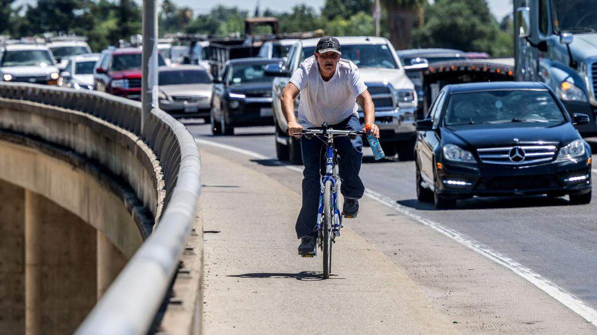 A bicyclist rides on the Highway 70 bridge as traffic backs up before the detour through downtown Marysville on Monday, July 1, 2024.