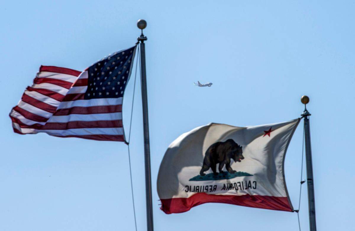A Southwest plane leaves Sacramento International Airport in 2021 as flags blow in West Sacramento.