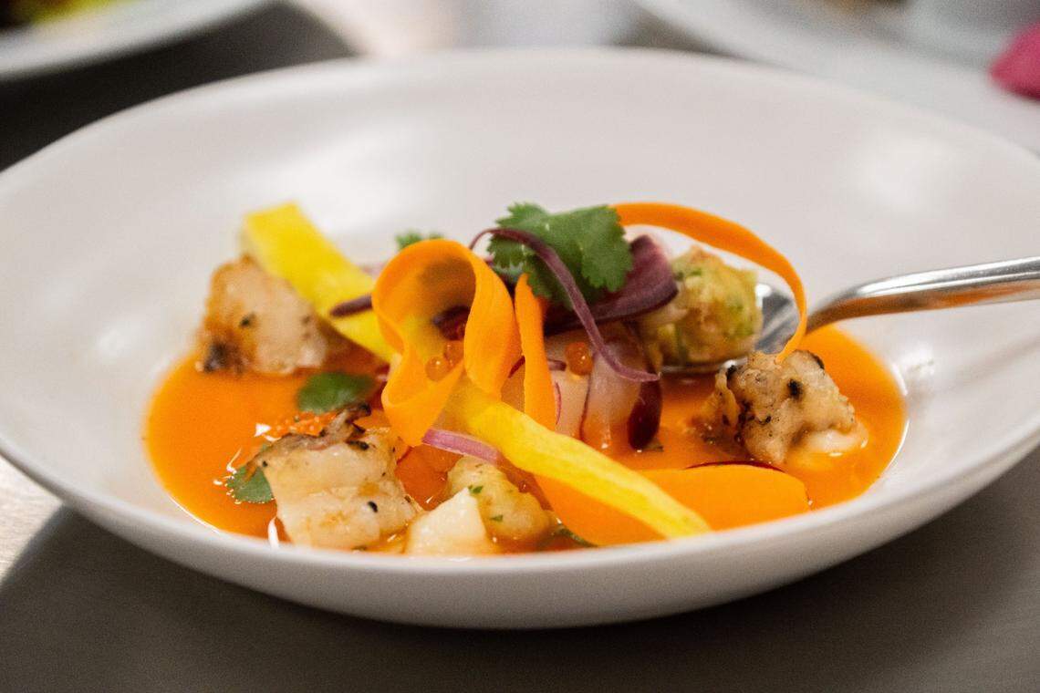 Carrot-habanero aguachile sits on display during this year’s Tower Bridge Dinner menu preview at the Central Kitchen in Sacramento on Monday. This first-course dish from Nash & Proper chef/co-owner Cecil Rhodes II is made with scallops, clams, shrimp, cured blue crawfish and corn pudding.