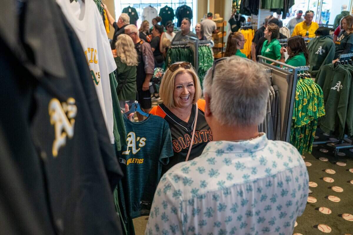 Kim Stanton shows her husband Jim a shirt in the Athletics team store before the team’s first game against the San Fransisco Giants at Sutter Health Park on July 4.