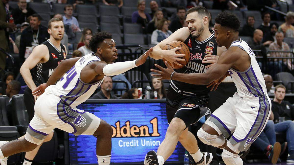Kings guards Buddy Hield, left, and Yogi Ferrell defend against Melbourne United guard Chris Goulding, center, during a preseason game Wednesday at Golden 1 Center.