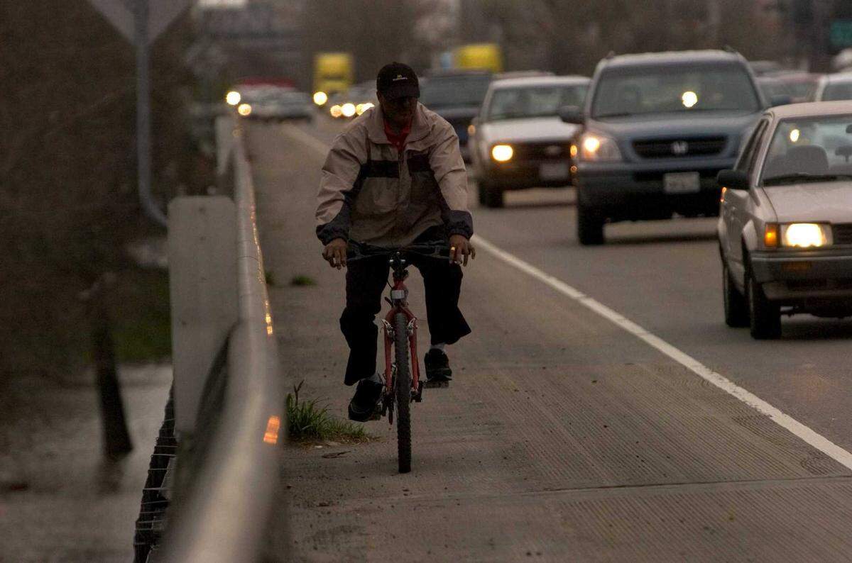 A cyclist rides north on the shoulder of Interstate 5 in 2006 due to flooding in Discovery Park. The city’s Active Transportation Commission is urging the city to consider making a new bridge across the American River car-free but past decisions only allow the city’s Public Works Department to consider building a new bridge with cars.