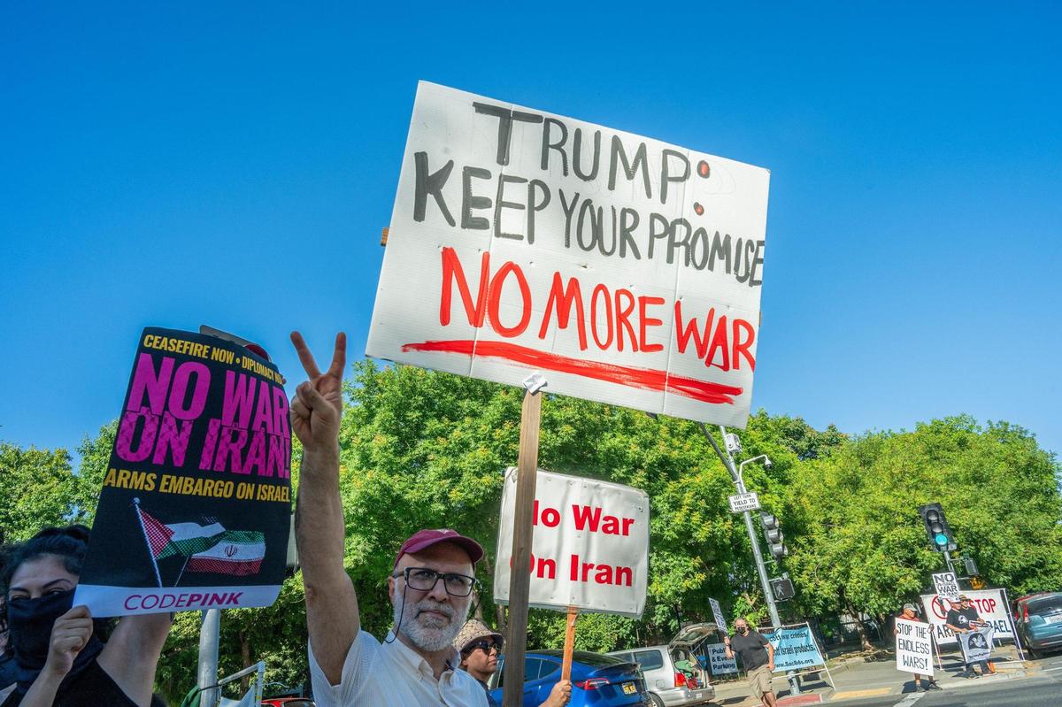 Farshid Zabihian, a faculty member at Sacramento State, holds a “no more war” sign on the corner of 16th and J streets in Sacramento on Wednesday. He and his family are from Iran, and he said he didn’t vote for Trump but believes those who did should be concerned about the president breaking his promise to avoid new wars.