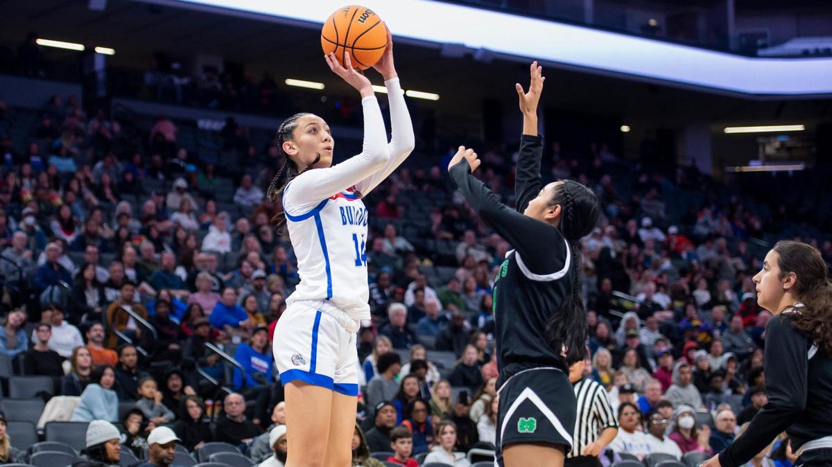 The Folsom Bulldogs’ Kamryn Mafua (14) makes a jump shot over St. Mary’s Rams guard Mia Jamias during the Sac-Joaquin Section Division I girls basketball championship game in February at Golden 1 Center. The Bulldogs won 58-53.