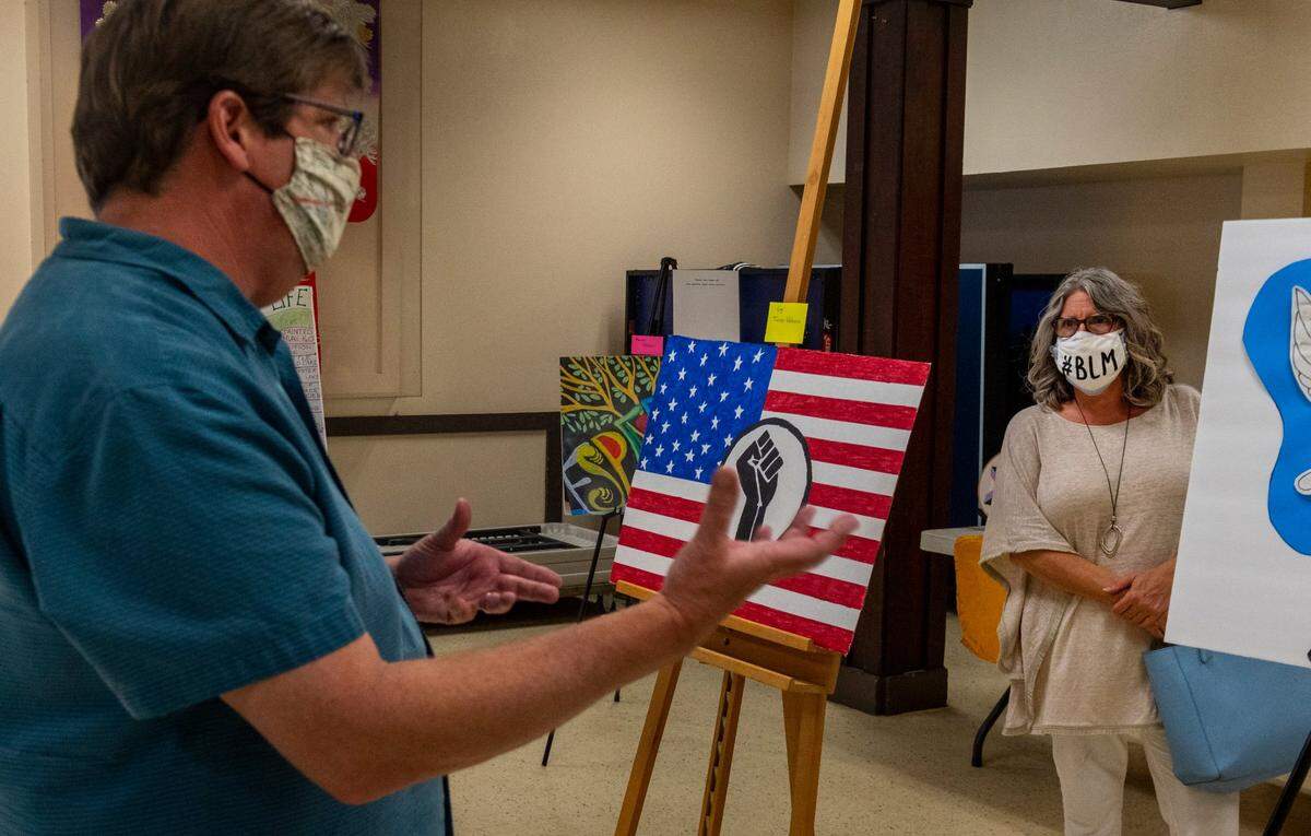 Co-founder of El Dorado Progressives Sean Frame, left, speaks with an attendee of “Standing Against Racism with Art” show held by the Civil Rights Now in Placerville, on Friday.