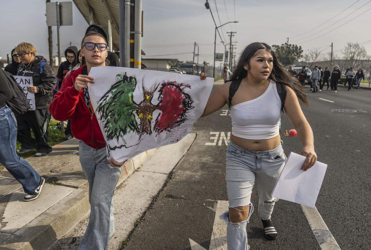 Gianni Miller and Carla Ruelas, students at Burbank High School, march on Florin Road during a student-led march against ICE to the state Capitol on Friday.