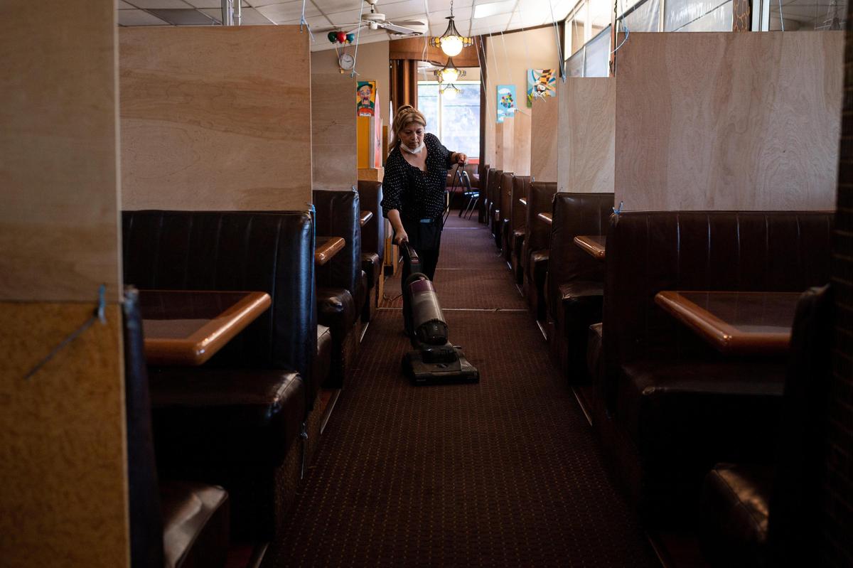 Pancake Circus server Cecilia Garcia vacuums between tables Friday, May 22, 2020, at the longtime restaurant on Broadway in Sacramento. The restaurant was getting ready for a full-service opening for Saturday morning, with precautions in place to prevent the spread of COVID-19, as allowed under new orders issued by Sacramento County. Co-owner Nicholas Ruebel said the barriers they added between tables meets a 5-foot height requirement mandated by the county.