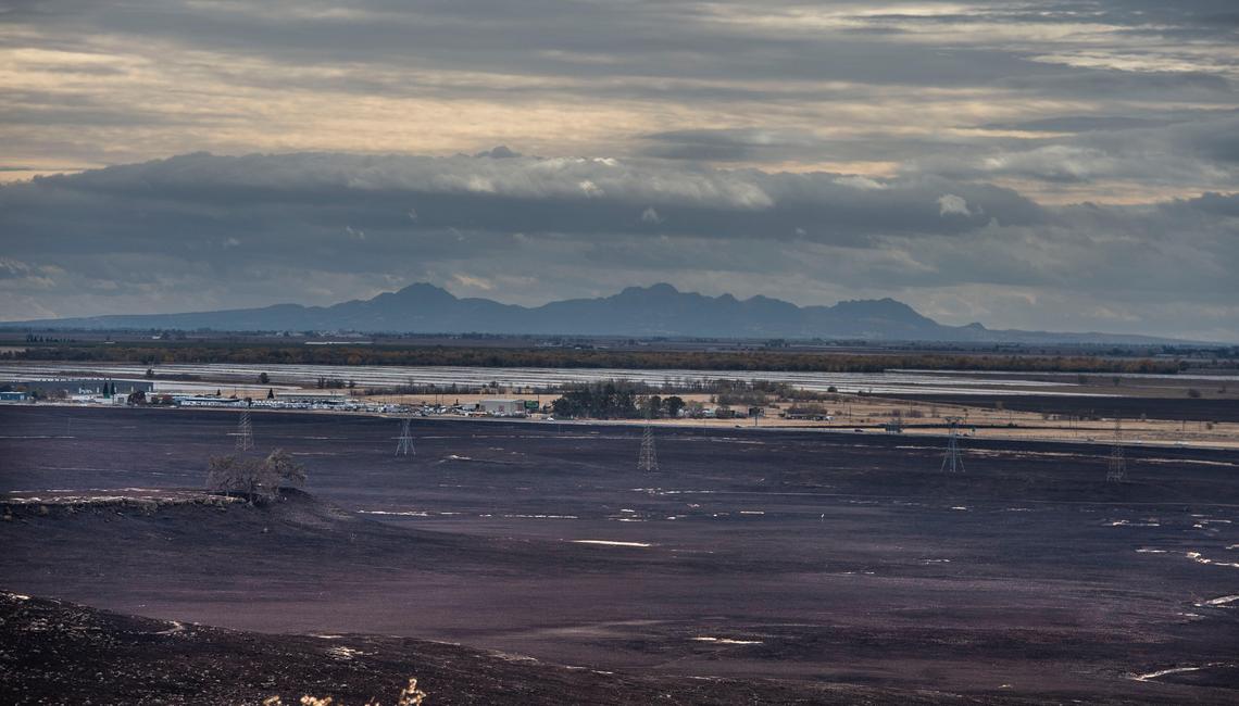 Clouds have helped clear the sky in Butte County enough to be able to see the Sutter Buttes from Neal Road in southern Paradise on Thanksgiving Day, Nov. 22, 2018. The Camp Fire was stopped in some areas before it crossed on to Hwy. 99.