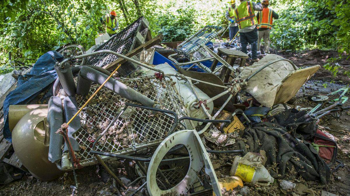 Sacramento County crews clean up one man’s homeless camp in the American River Parkway in Sacramento in 2018.