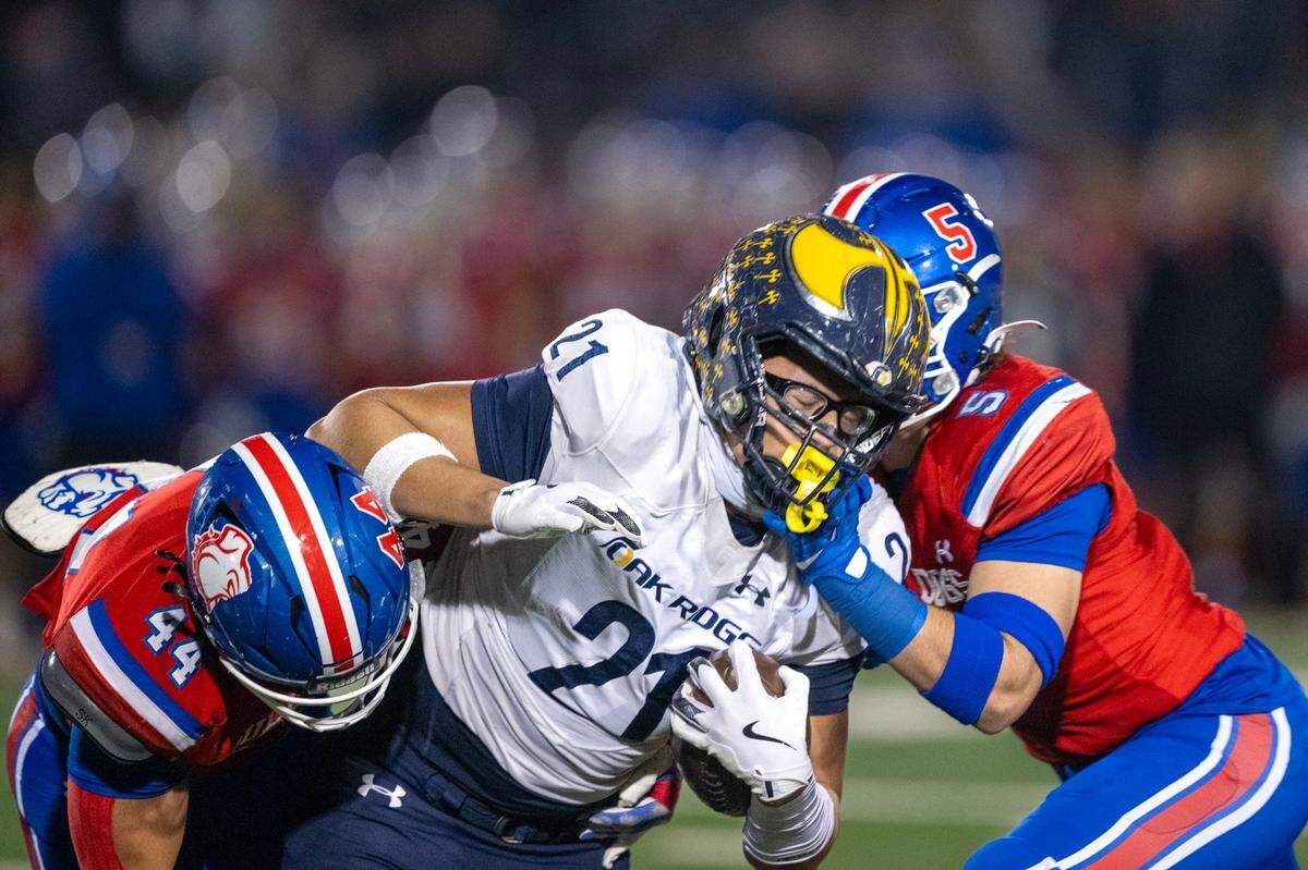 Oak Ridge Trojans tight end Kaleb Edwards is tackled by Folsom Bulldogs defenders in the Sac-Joaquin Section Division l football championship game in November. Edwards is The Bee’s Large School Player of the Year.