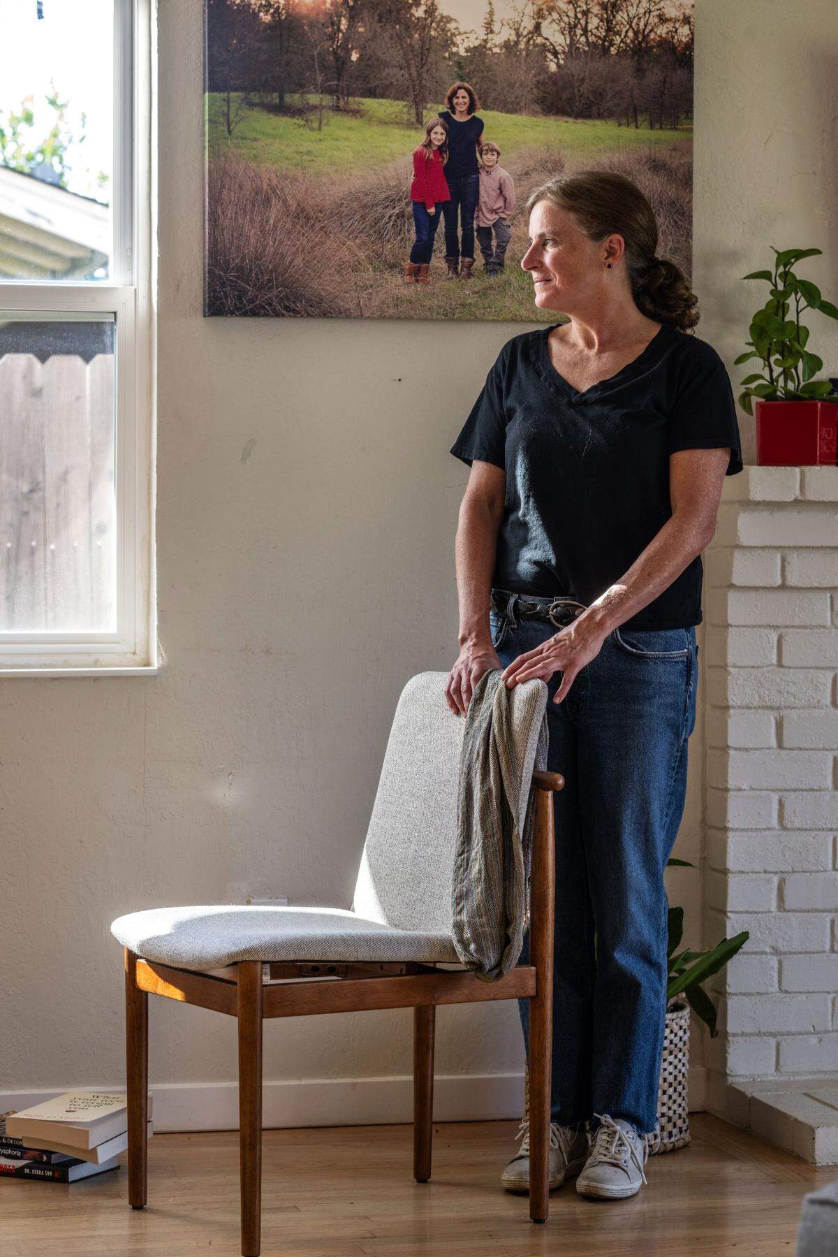 Beth Bourne, chapter president of Moms for Liberty Yolo County, stands in her Davis home near a photograph with her children.