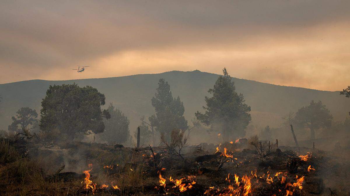 An air attack helicopter drops water on hot spots battling the Lava Fire on Tuesday, June 29, 2021, outside of Weed in Siskiyou County.