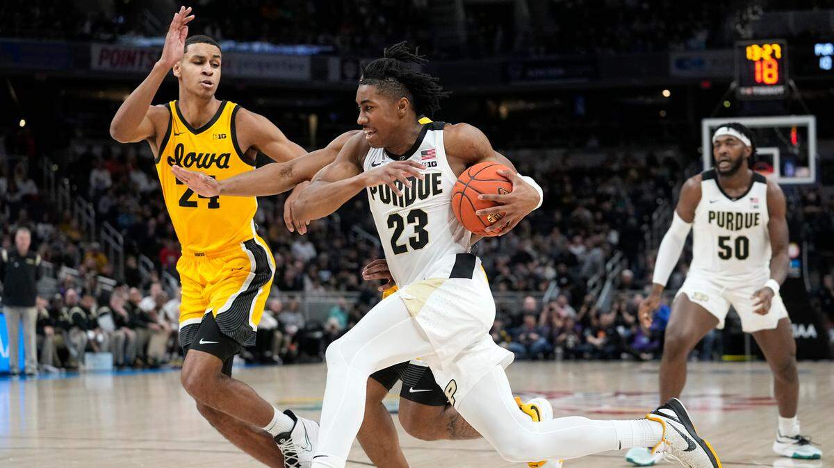 FILE - Purdue guard Jaden Ivey (23) drives to the basket next to Iowa forward Kris Murray (24) during the first half of an NCAA college basketball game at the Big Ten tournament March 13, 2022, in Indianapolis. Ivey is the headliner among point guard prospects in next week’s NBA draft. (AP Photo/Darron Cummings, File)