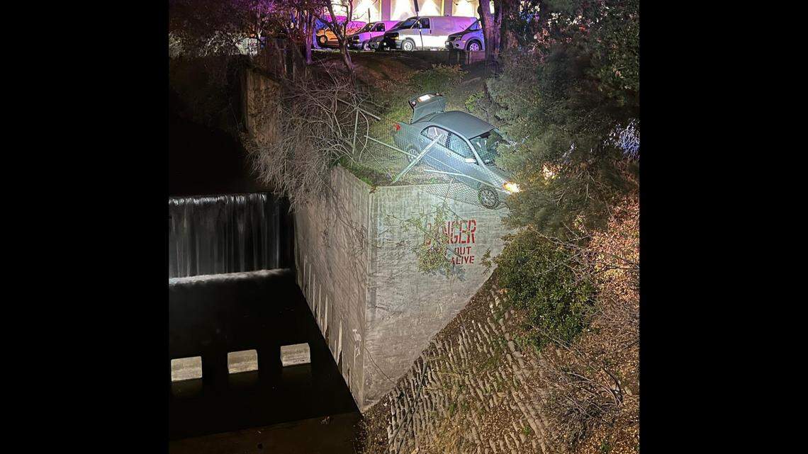 A driver wound up hanging off a 40-foot concrete wall over a canal after trying to flee police in Walnut Creek, California, officers say.