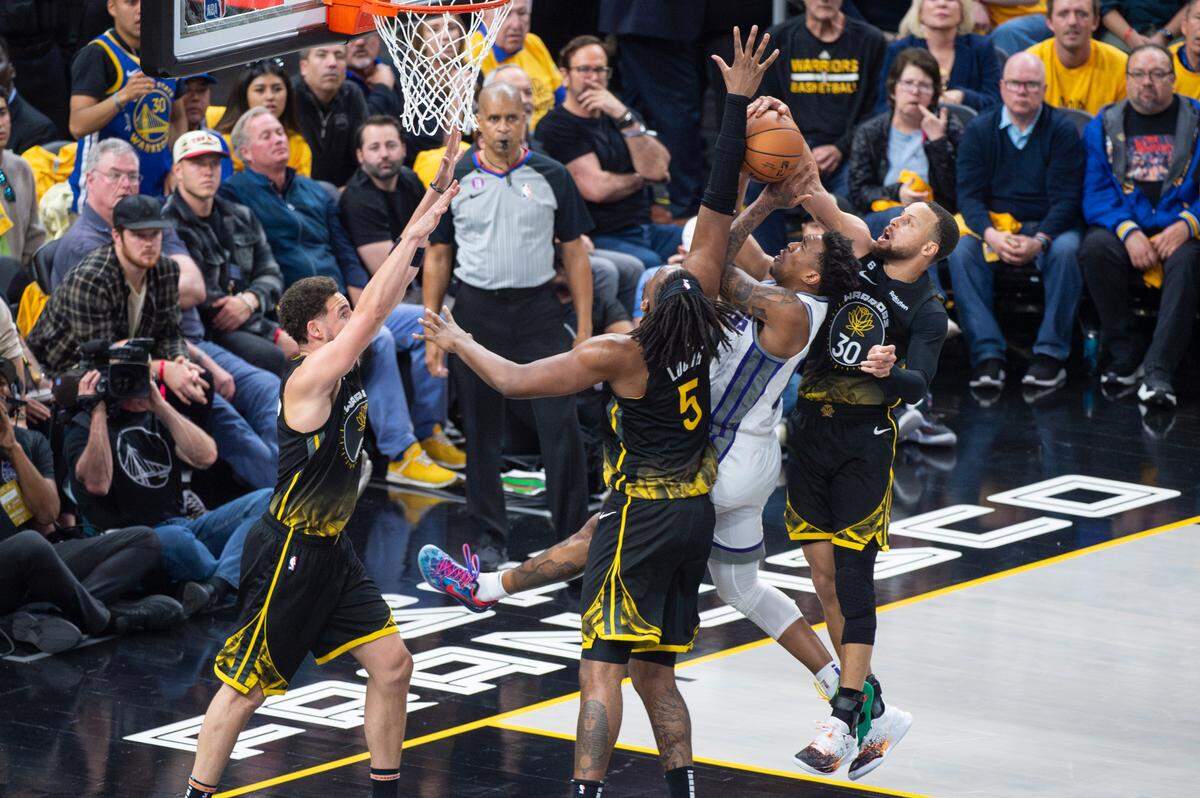 Golden State Warriors guard Stephen Curry (30) blocks Sacramento Kings guard Malik Monk (0) in the first half during Game 3 of the first-round NBA playoff series at Chase Center in San Francisco on Thursday, April 20, 2023.