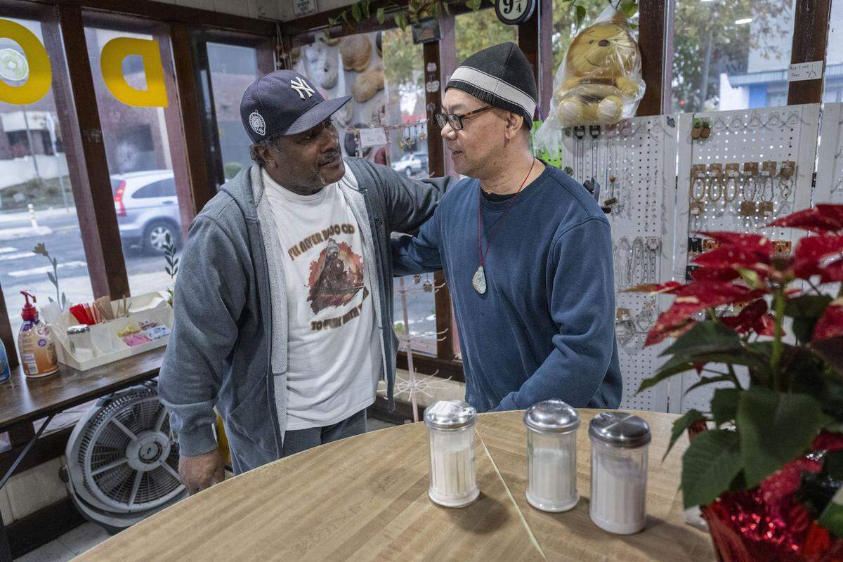Lee Washington, of Elk Grove, hugs former Broadway Donuts owner Josan So on Friday. 