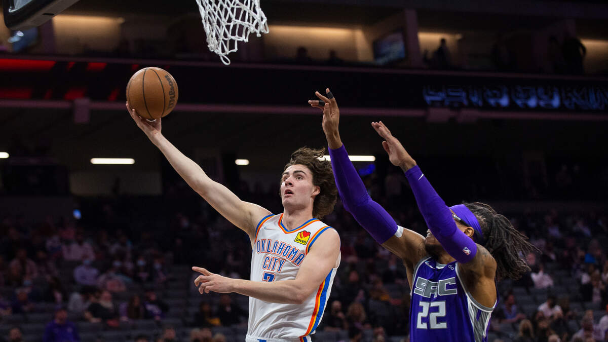 Oklahoma City Thunder guard Josh Giddey (3) lays the ball up as Sacramento Kings center Richaun Holmes (22) defends during the first quarter of an NBA basketball game in Sacramento, Calif., Saturday, Feb. 5, 2022. (AP Photo/Randall Benton)