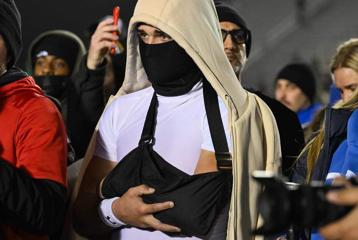 Injured Folsom quarterback Ryder Lyons cradles his arm after his team defeated the Riordan Crusaders 42-38 In the CIF Northern California Regional Division 1-AA football championship game in Folsom on Friday.