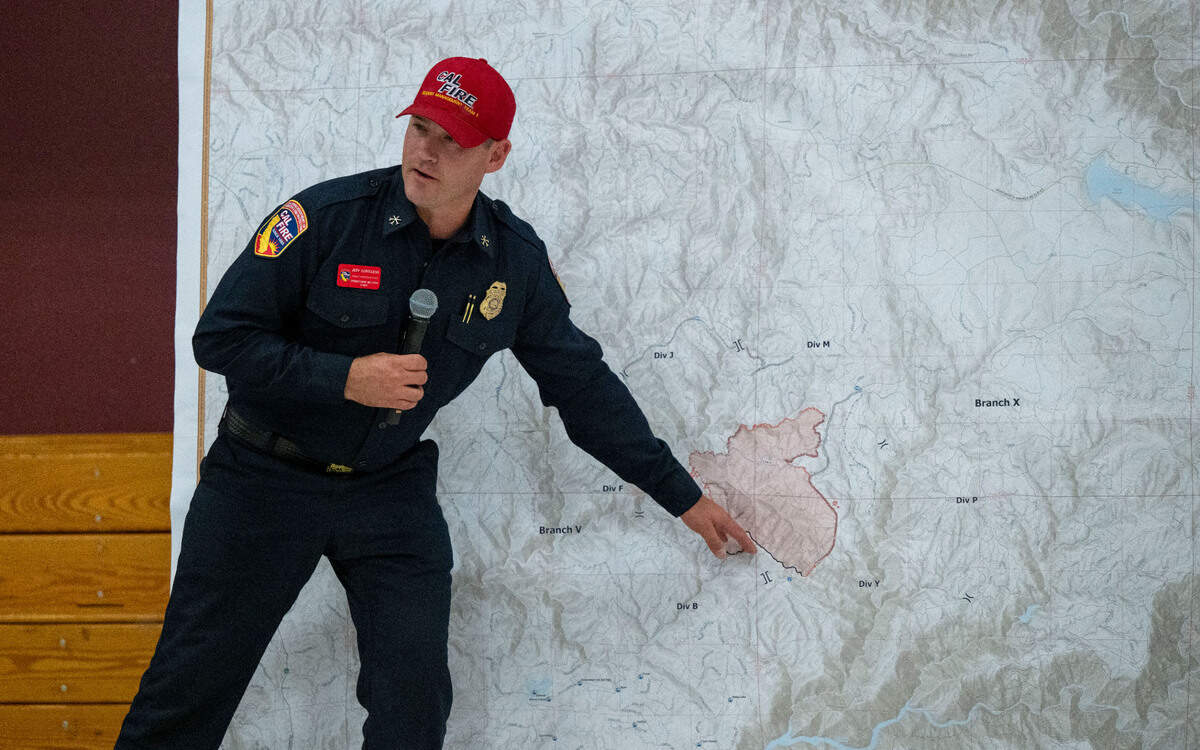Cal Fire Operations Section Chief Jeff Loveless refers to a map to show where the Crozier Fire is active during a town hall meeting at Sutter’s Mill School in Placerville on Sunday.