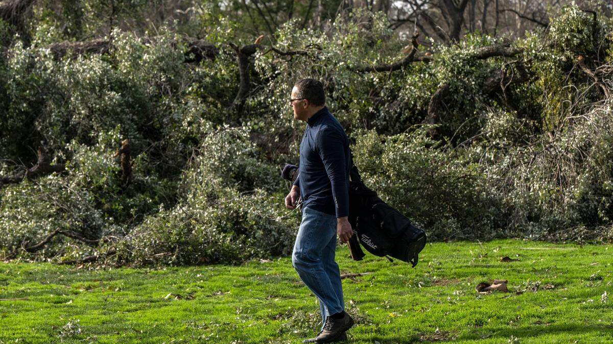 Nate Simon of Sacramento walks to the 5th hole at William Land Golf Course on Thursday, Jan. 12, 2023, past fallen trees. “I grew up here and haven’t seen anything like this. It’s a different world,” said Simon referring to the recent rash of winter storms and windy weather.
