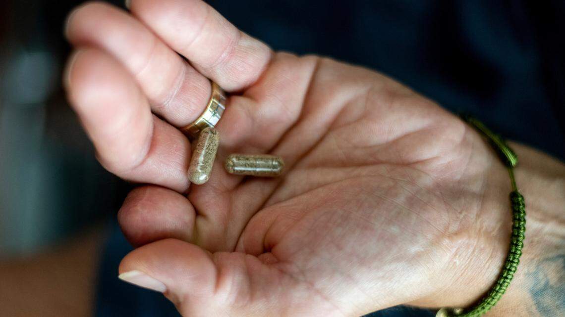 Jose Martinez holds capsules of psilocybin mushroom that uses to ease pain and discomfort.