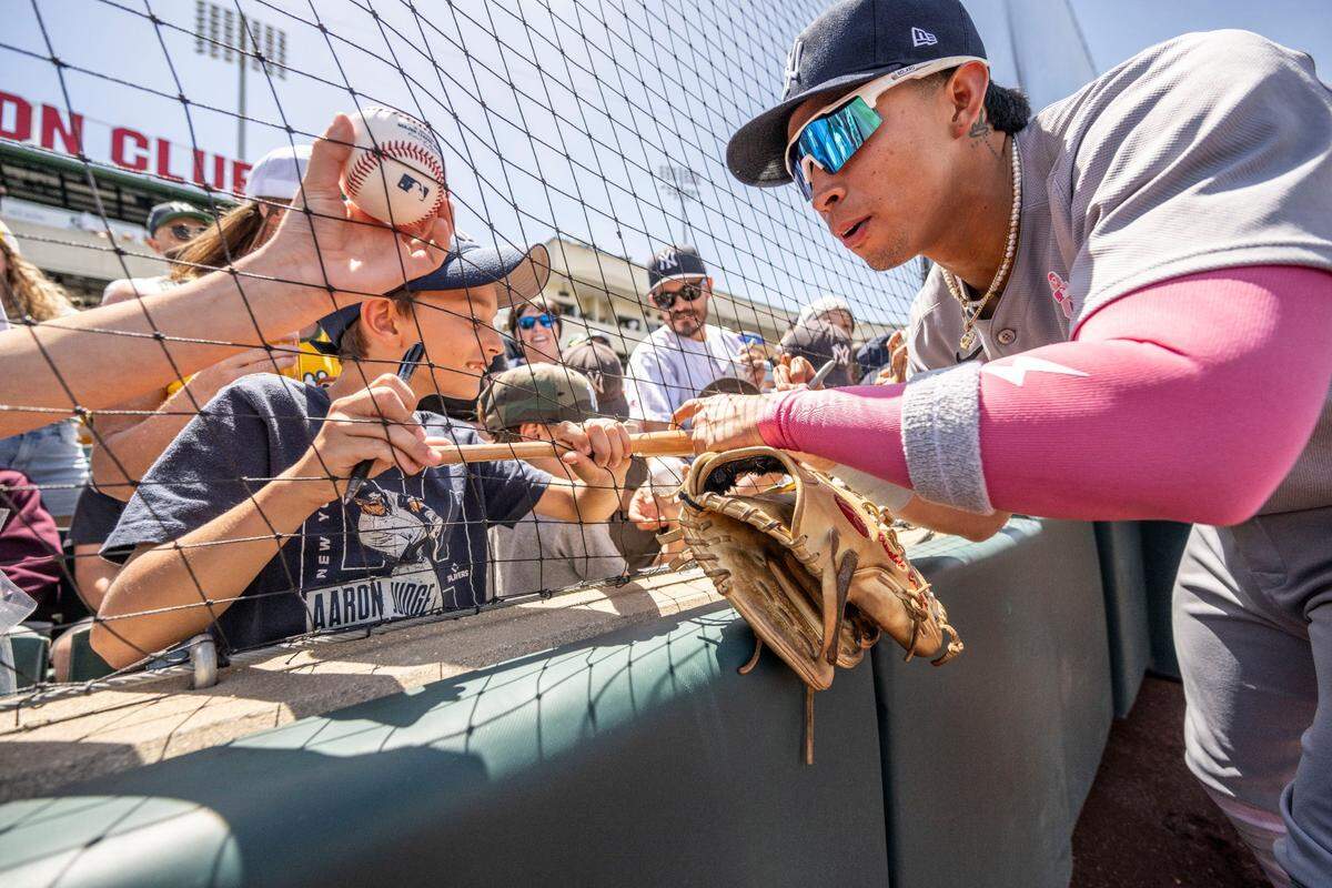 Eight-year-old Jackson Jacobs, of Sacramento, has a miniature bat signed by New York Yankees third baseman Oswaldo Cabrera before a 2025 game against the Athletics at Sutter Health Park in West Sacramento. 