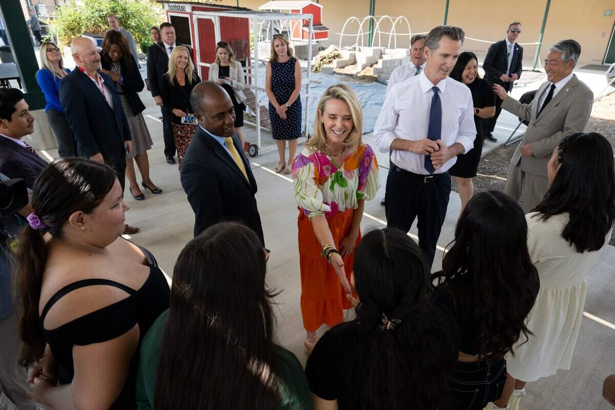 California First Partner Jennifer Siebel Newsom, center, greets a student while she stands with state Superintendent of Public Instruction Tony Thurmond and Gov. Gavin Newsom at River City High School in West Sacramento on Thursday.