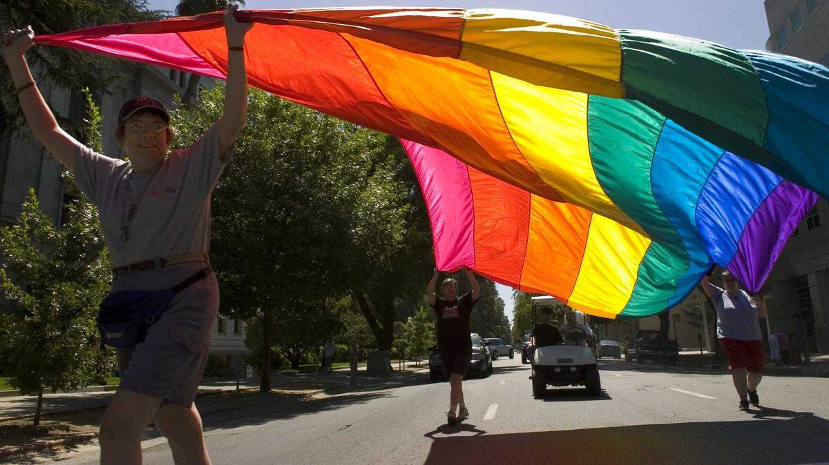 Kathy Johnson, front left, Judy Saint, back left, and Michele Masonheimer carry a gigantic rainbow flag during the Gay Pride parade from the state Capitol to Southside Park in 2007.