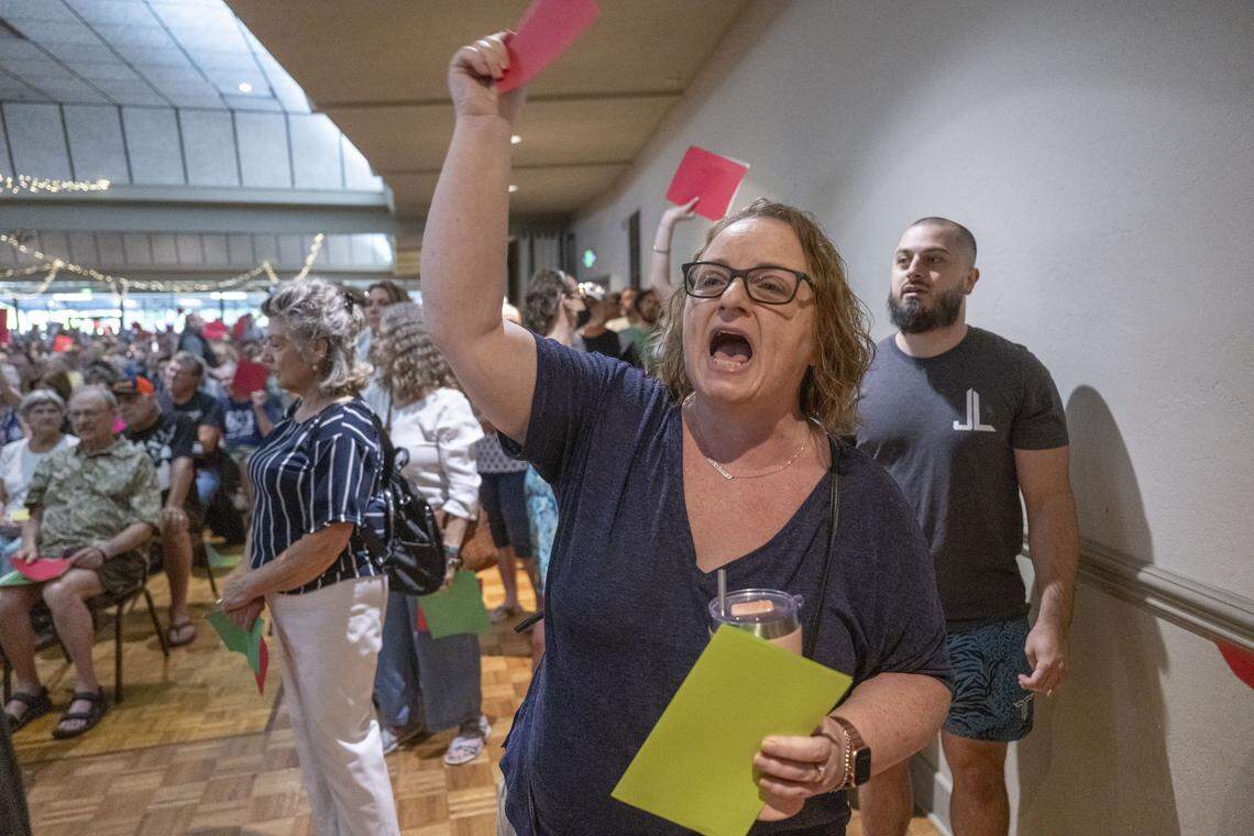 Sarah Morris, of Chico, yells in disapproval and holds a red card as Rep. Doug LaMalfa, R-Oroville, holds a town hall meeting on Monday in Chico.