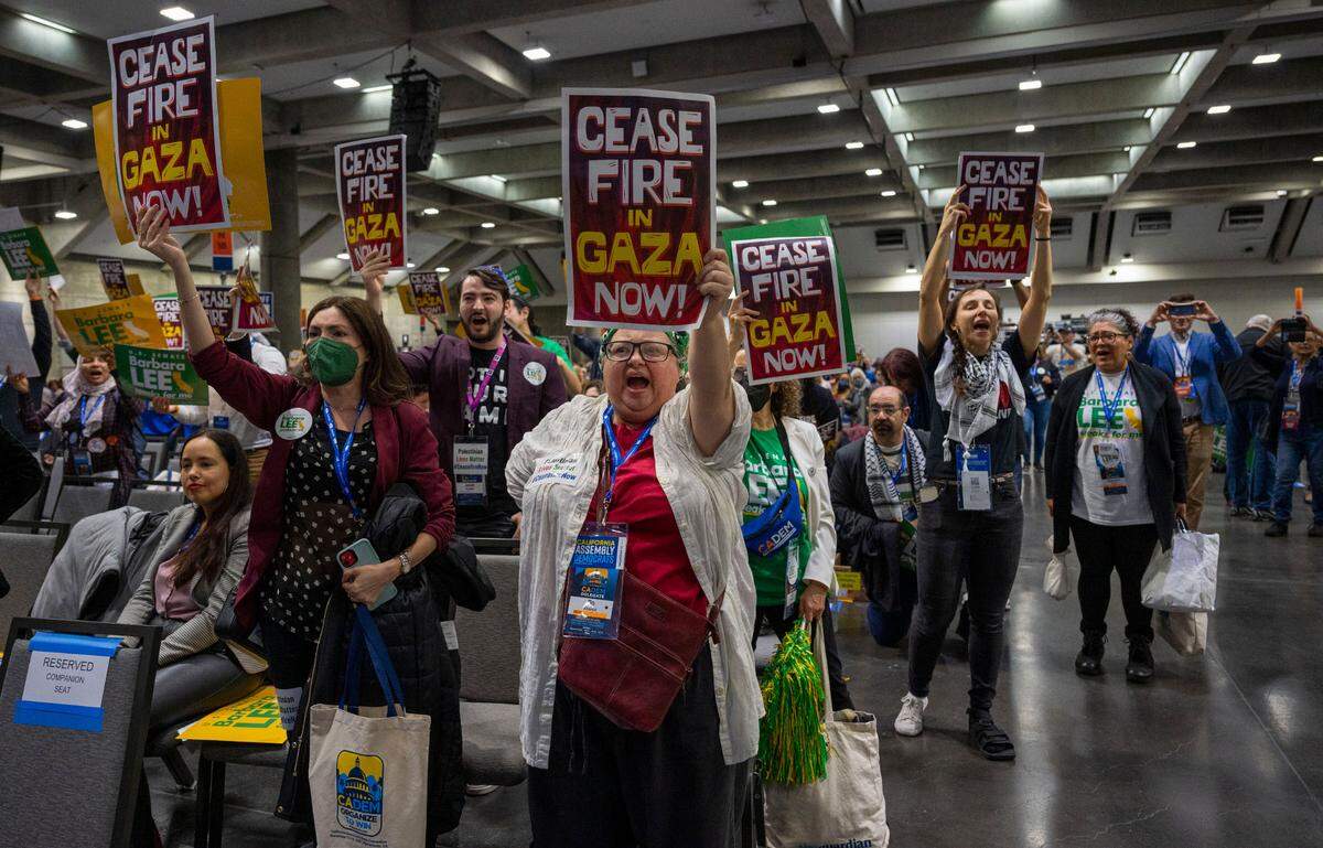 Supporters of U.S. Senate candidate Barbara Lee hold signs calling for a cease-fire in the Israel-Hamas war as she speaks at the Democratic nominating convention at SAFE Credit Union Convention Center.