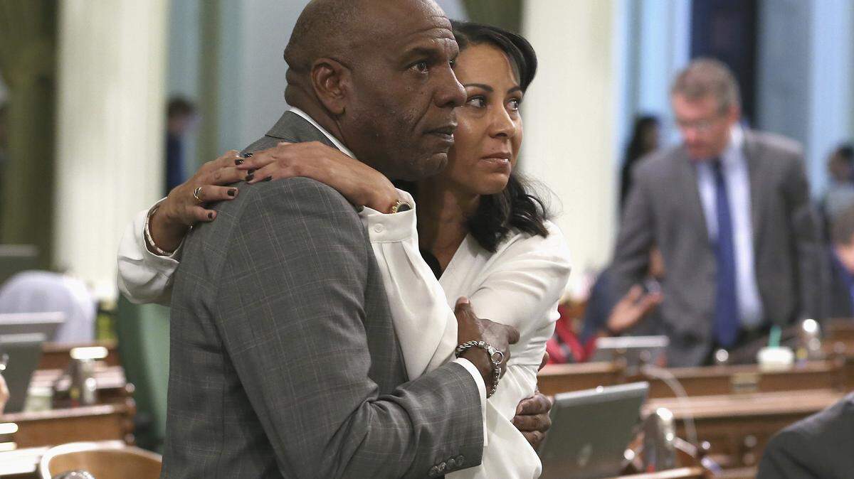 Los Angeles-area Democrats Sen. Steven Bradford and Assemblywoman Autumn Burke hug Aug. 30 after the state Assembly approves a bill stating that voter registration will be the sole factor determining whether a legislator lives in their district.