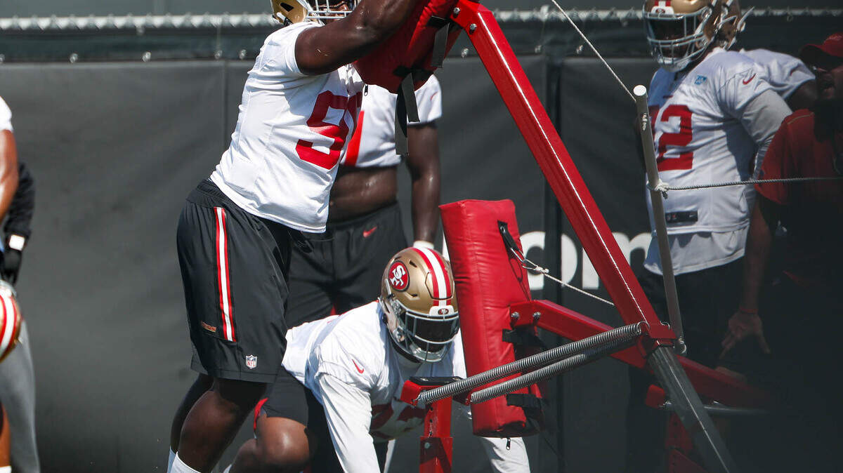 San Francisco 49ers’ Javon Kinlaw (99), left, pushes a practice sled during a drill at practice at Levi’s Stadium in Santa Clara, Calif., on Sunday, Aug. 16, 2020.