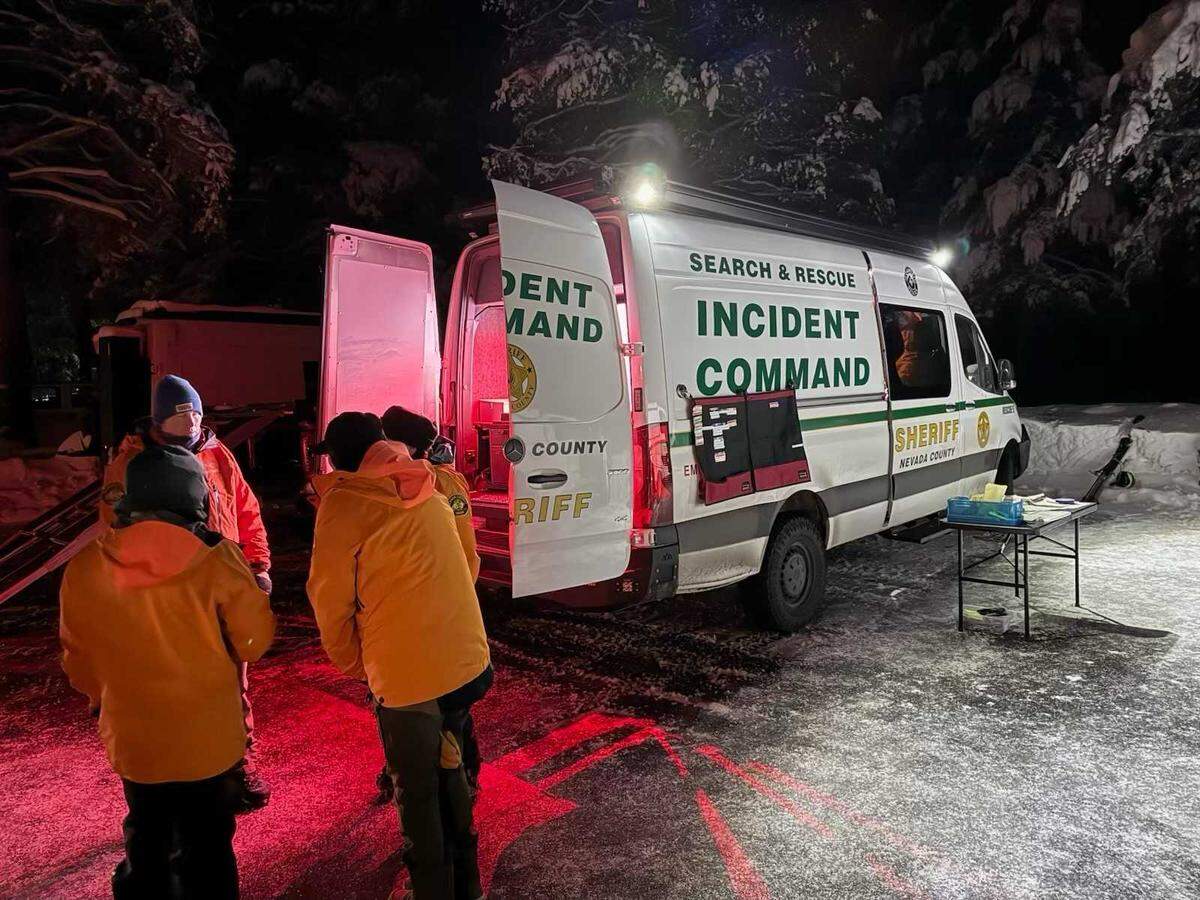 Emergency responders gather near incident command vehicles in a snowy staging area near Castle Peak in Nevada County, Calif., on Monday, Jan. 5, 2026. Authorities were searching for possible victims after an avalanche killed a snowmobiler in the backcountry near Truckee earlier in the afternoon.