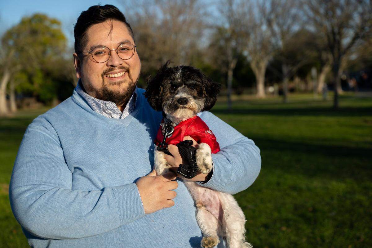 Joaquin Razo holds his 7-month puppy Tobias, a.k.a. Dee-Bone Samuel, in Sacramento’s Tahoe Park on Monday, Jan. 27, 2025. Toby is a contestant in this year’s Puppy Bowl XXI, which airs on Animal Planet on Superbowl Sunday.