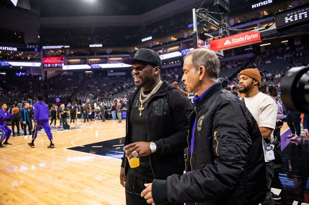 Rapper, businessman and actor 50 Cent (Curtis Jackson) walks with Sacramento Kings owner Vivek Ranadivé to their courtside seats before the NBA basketball game against the Indiana Pacers on Wednesday, Nov. 30, 2022, at Golden 1 Center in Sacramento.