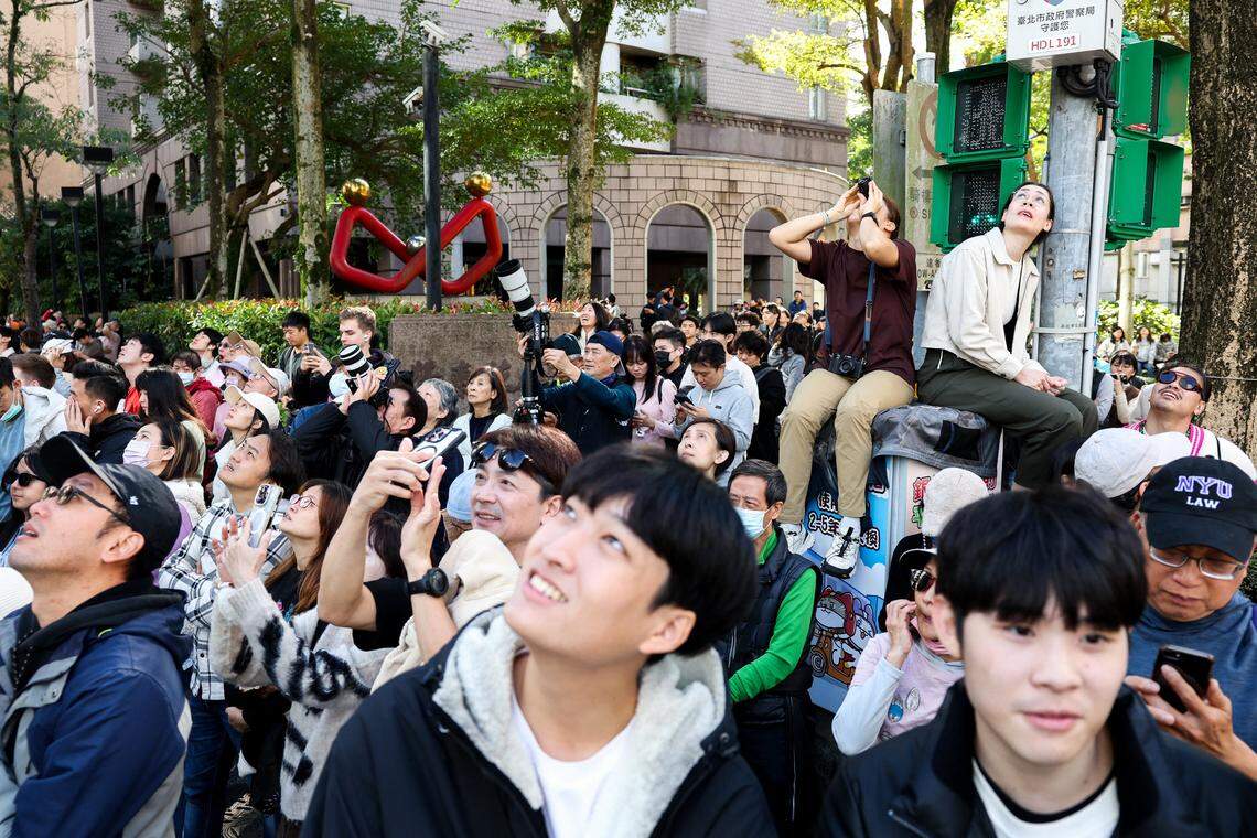 TOPSHOT - People watch US rock climber Alex Honnold scale the Taipei 101 building without ropes or safety gear in Taipei on January 25, 2026. (Photo by I-Hwa Cheng / AFP via Getty Images)