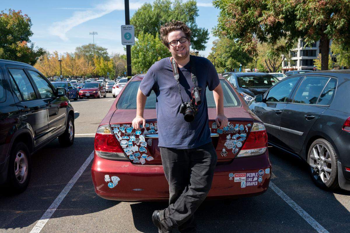 Cameron Caves, a film student at Sacramento State, stands against his 2006 Toyota Camry in a campus parking lot earlier this month. Like many Californians, Caves wants an electric car but can’t afford one. Affordability is among the many challenges standing in the way of California’s mandate that new vehicles sold in the state must be zero-emission by 2035.