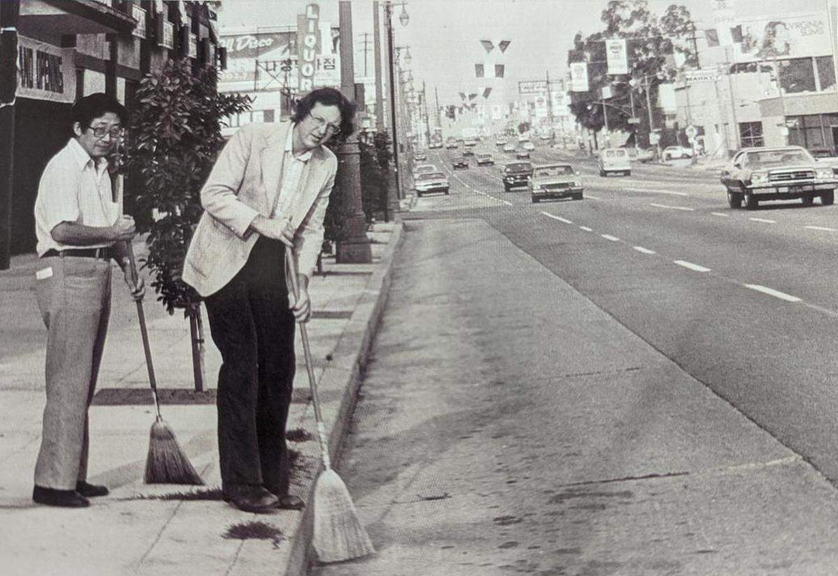 K.W. Lee, left, and Steve Chanecka sweep streets before a Korean festival.