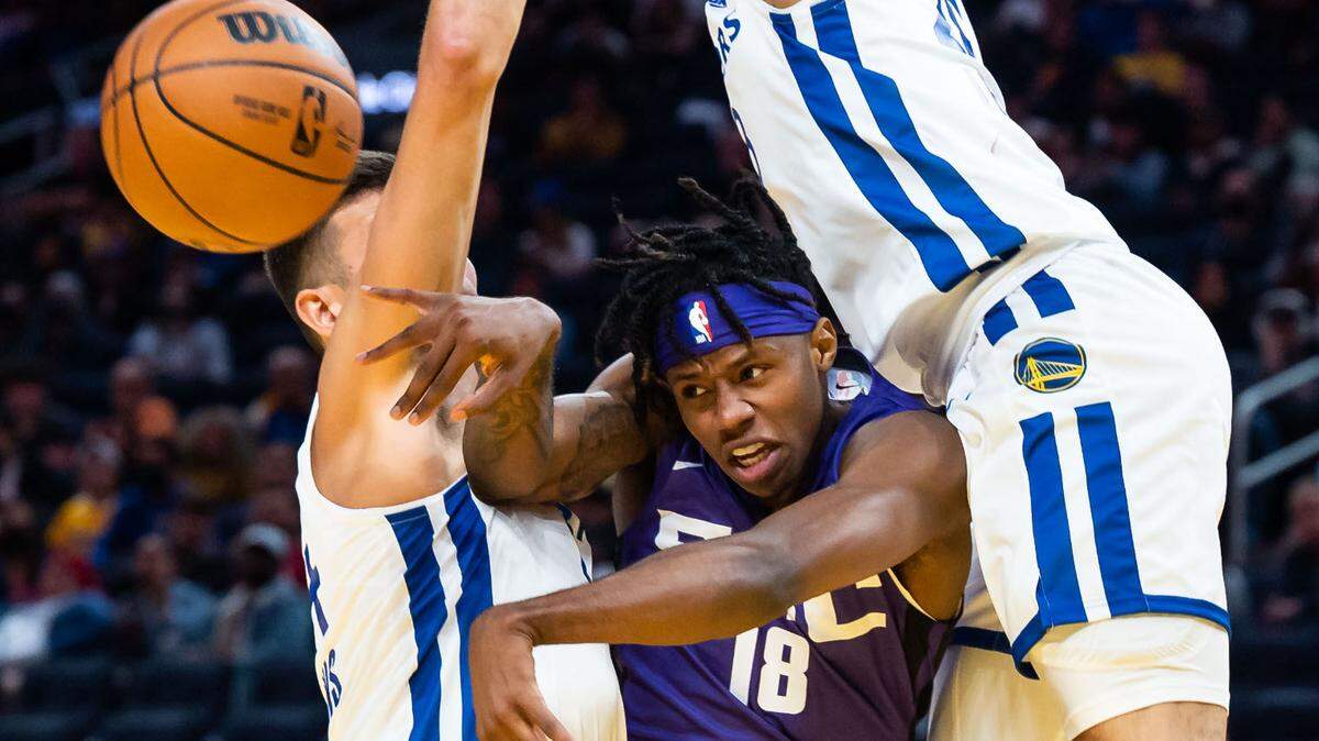 Sacramento Kings guard DJ Steward (18), center, is fouled while passing out between Golden State Warriors forward Ryan Hawkins (44), left, and guard Kalob Ledoux (28) during the fourth period at the California Classic NBA preseason basketball game Saturday, July 2, 2022, at Chase Center in San Francisco.
