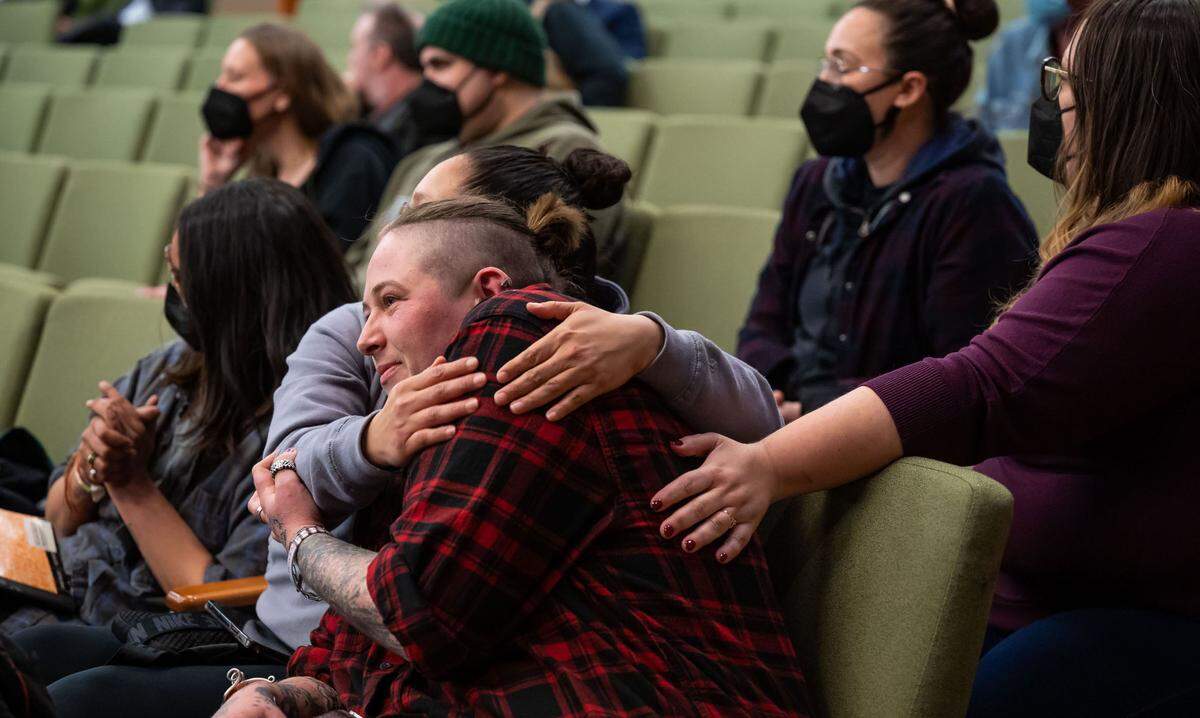Community activist Mackenzie Wilson, center, is embraced by labor organizer Fatima Garcia after both spoke during public comment Tuesday, calling for police reform and criticizing the City Council for homeless sweeps. “I’m exhausted from having to fight you always. In the last few weeks you militarized police, tried to intimidate a vigil full of people they traumatized or almost killed in 2020, and then bought a tank on the consent calendar,” Wilson said.
