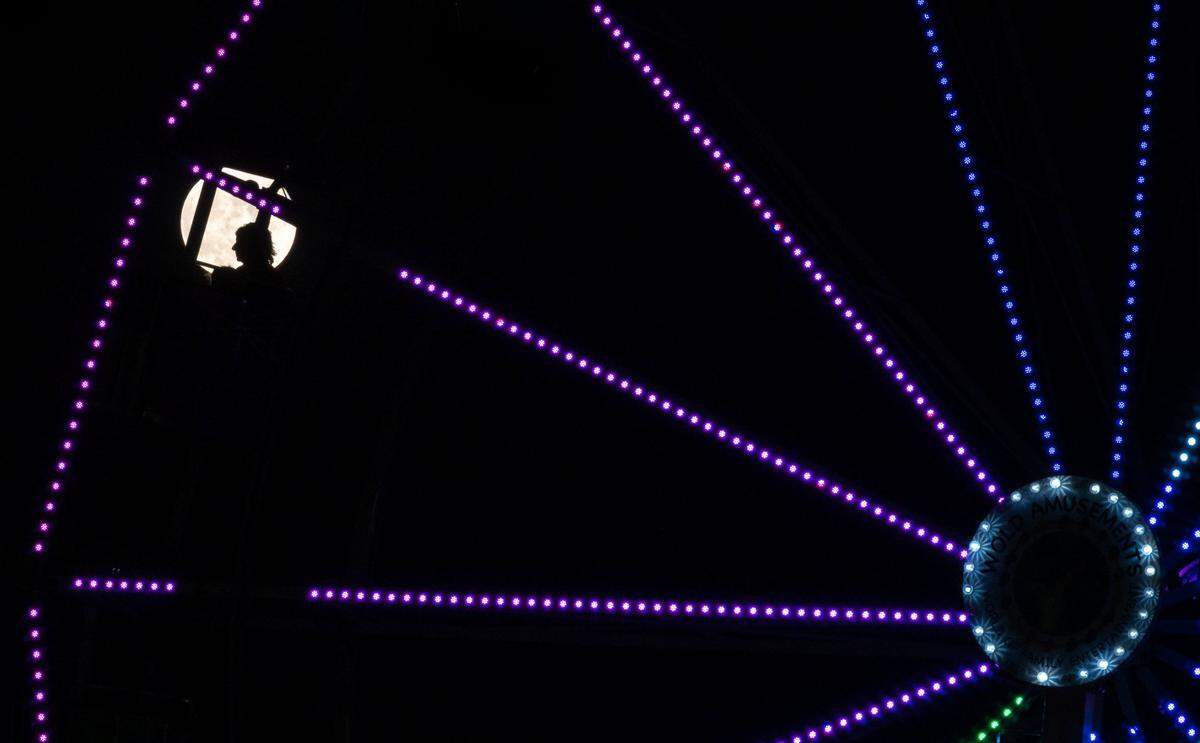 People ride the Wold Amusements Ferris wheel in view of the strawberry full moon Thursday, June 24, 2021, on opening night at the Placer County Fair in Roseville. Junes full moon is traditionally called the Strawberry Moon, according to the Old Farmers Almanac, by&nbsp;Algonquin, Ojibwe, Dakota and Lakota peoples, among others, to mark the ripening of June strawberries. Its considered by many to be the last supermoon of 2021.