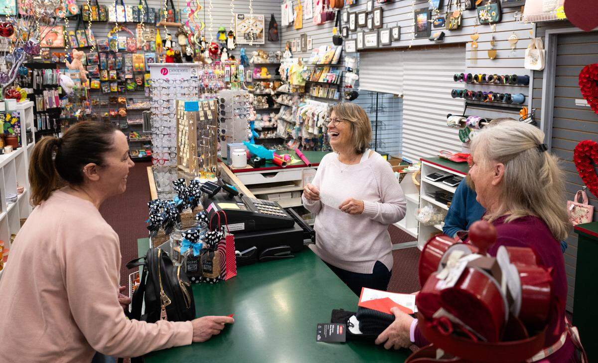 Manager Wendy Gray, center, shares a laugh with longtime customer Cheryl Mohr at Mixed Bag, a beloved midtown Sacramento gift shop, on Thursday. The shop’s 47-year run will end in March. 