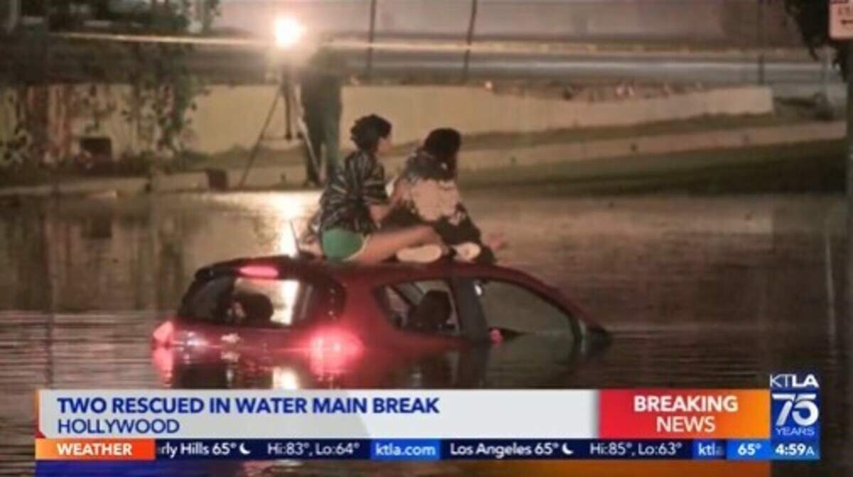 Flooding from a water main break in Hollywood trapped two women on top of a car and left other vehicles underwater, California officials say.