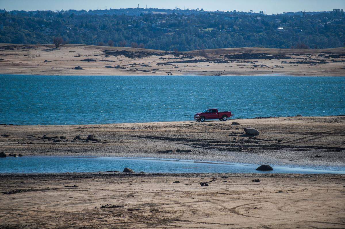 A truck is parked on the sand at Folsom Lake near Granite Bay on Tuesday, Jan. 26, 2021.