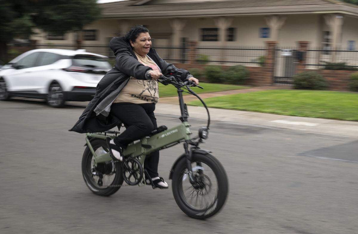 Anna Crespo, 55, rides her e-bike in Sacramento on Thursday.