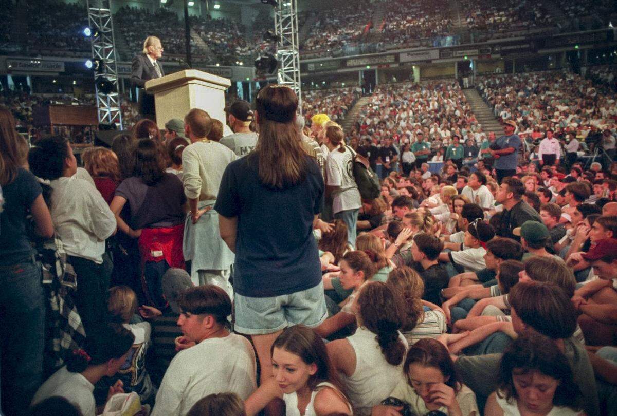 Hundreds of young people crowd around the Rev. Billy Graham to hear his message on youth night, Oct. 21, 1995, the fourth night of his “Greater Sacramento Crusade,” at Arco Arena in Sacramento.