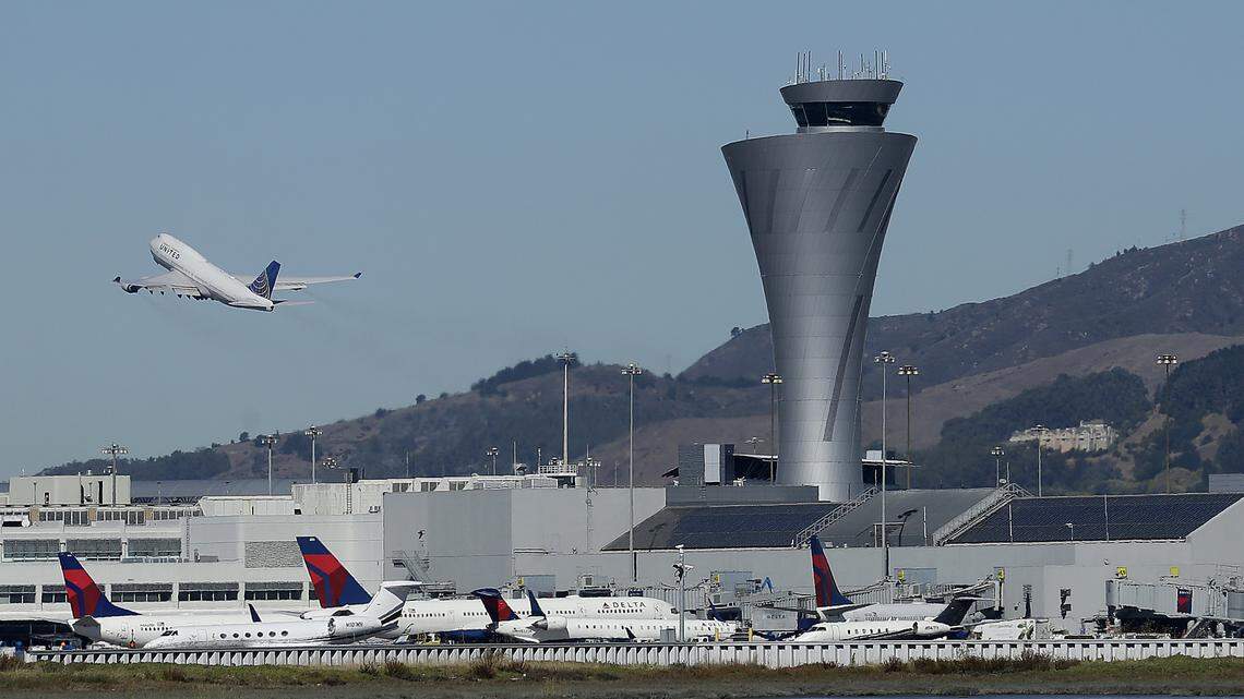 The air traffic control tower is in sight as a plane takes off from San Francisco International Airport in October. Kevin Prasad, 31, faces charges that he murdered the boyfriend of an airport co-worker in an attempt to pursue a romantic relationship with the woman himself, San Mateo County officials say.