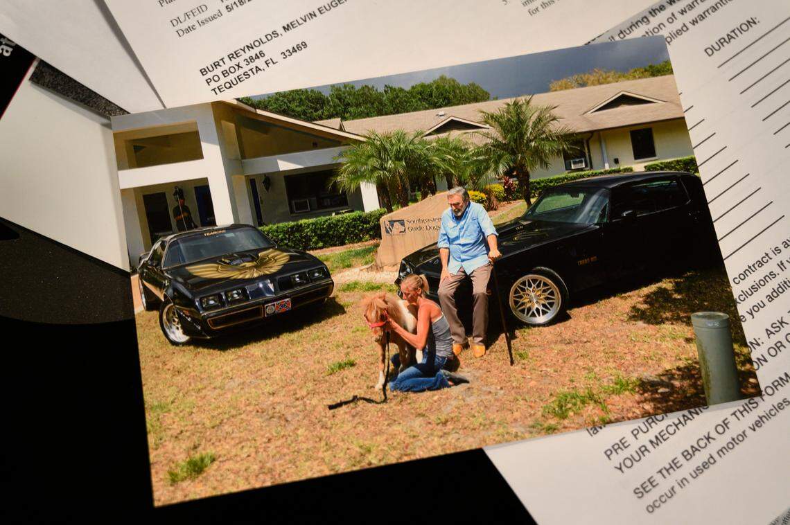 The registration for a 1978 Pontiac Trans Am once owned by Burt Reynolds rests behind a picture of the actor sitting on the hood of the car. The car is one of approximately 180 rare vehicles seized by the federal government that are housed in a warehouse in Woodland. About 150 of these cars will be auctioned off in on Saturday, Oct. 26, in the largest single-owner auction ever for the U.S. Marshall Service. The value of the cars to be auctioned is estimated at $3 million.